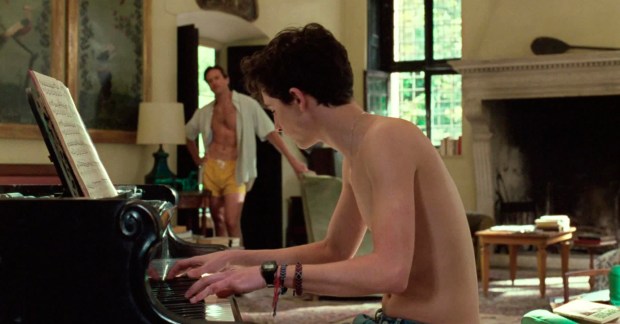 Elio (Timothée Chalamet) tocando el piano mientras Oliver (Armie Hammer) lo escucha